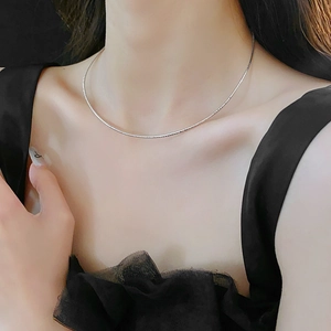 Minimalist silver round snake chain necklace on collarbone with polished metallic shine