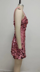 Detailed close-up of pink sequin fabric and rhinestone straps on an A-line mini dress