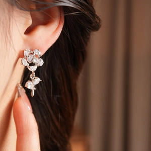 Vue macro de boucles d'oreilles fleurs en argent avec zircons sur un mannequin