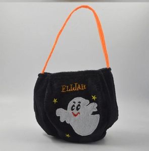 Detail of plush black Halloween candy bag with embroidered ghost and orange handle strap