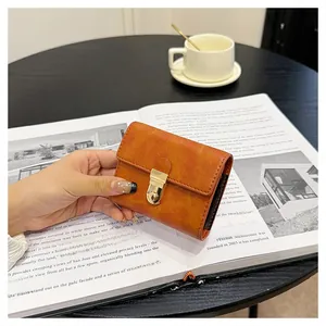 Detail of tan faux leather card holder with gold twist lock on architectural magazine