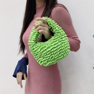 Detailed close-up of bright green mop plush texture and fuzzy material of the handbag
