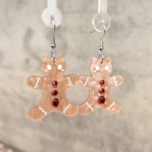 Vue détaillée des boucles d'oreilles chat en pain d'épices avec glaçage et strass rouges