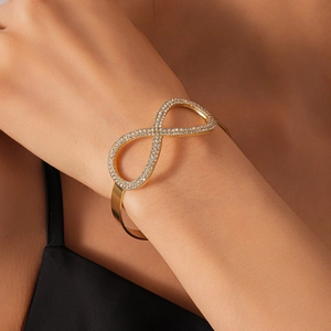 Dettaglio dell'elegante bracciale a infinito dorato con scintillanti zirconi bianchi