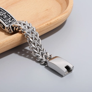 Macro detail of men's titanium steel bracelet with vintage engraved pattern and clasp