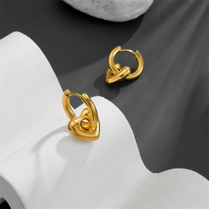 Minimalist golden heart drop earrings in polished stainless steel on a white display