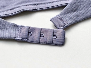 Detail of light purple ribbed cotton bra featuring a triple row of metal hook-and-eye closures