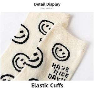 Close-up of elastic ribbed cuff on off-white cotton crew socks with smiley face pattern