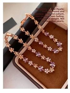Close-up of rose gold flower bracelet with white pearls and purple crystals in a gift box