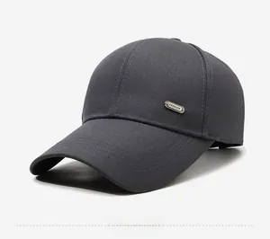 Détail de la casquette de baseball en sergé gris foncé avec logo en métal et bordure surpiquée