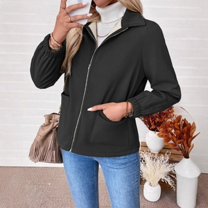 Detail of black zip-up jacket featuring a warm fleece collar and textured fabric for winter