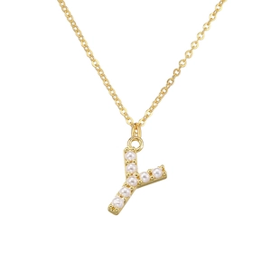 Macro detail of gold-plated letter Y pendant featuring inlaid white pearls on a chain
