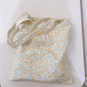 Detailed macro view of yellow floral pattern and fabric texture on white canvas tote bag