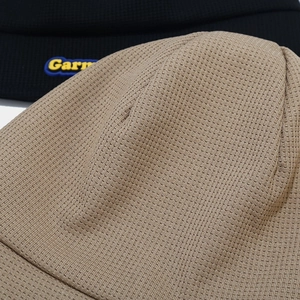 Detail of grid knit texture on khaki and black beanies with embroidered logo patch