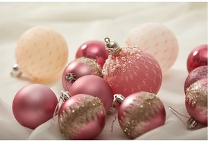 Detail von rosa und goldenen Weihnachtskugeln mit Spitze, Glitzer und Perlenverzierung