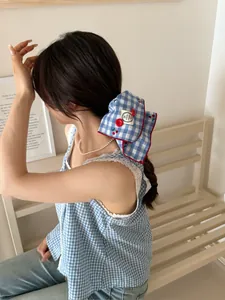 Detailed blue and white plaid fabric hairband with red trim and hand made tag
