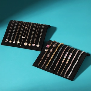 Elegant S-shaped jewelry display stands with assorted gold necklaces and pearl bracelets