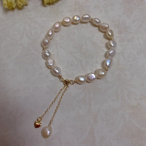 Close-up of baroque pearl bracelet with 14K gold-plated beads and adjustable heart charm