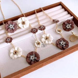 Detailed set of floral necklace, earrings and ring in a luxury brown velvet jewelry box