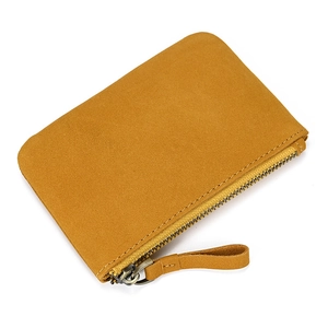 Detail of genuine leather coin purse showing mustard yellow suede texture and metal zipper