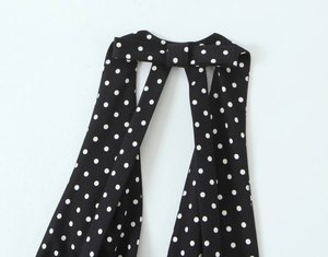 Détail du tissu à pois noirs et blancs avec un nœud décoratif sur la robe