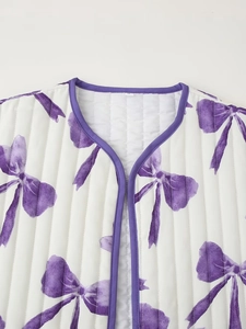 Close-up of white quilted vest with purple bow prints and matching piped collar edges