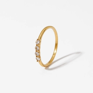 Elegant 316 stainless steel gold ring with four round cubic zirconia stones on white background