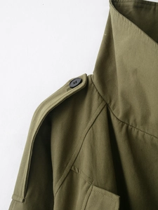 Detail of army green cotton canvas jacket showing epaulette with black button and texture