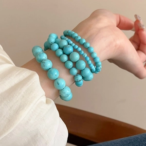 Detailed view of turquoise beaded stretch bracelet on wrist with vibrant blue natural stone