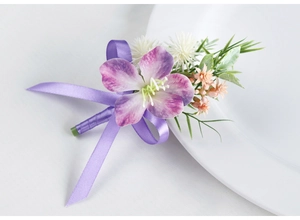 Detailed close-up of purple silk boutonniere with satin ribbon and greenery for weddings