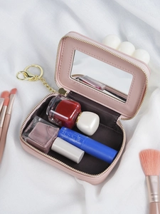 Pink mini makeup bag with interior mirror and gold keychain showing storage capacity