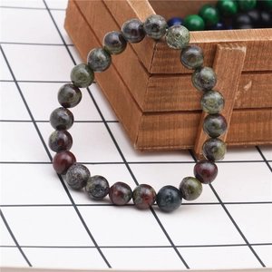 Macro detail of 8mm tiger eye agate beaded bracelet resting on a wooden gift box