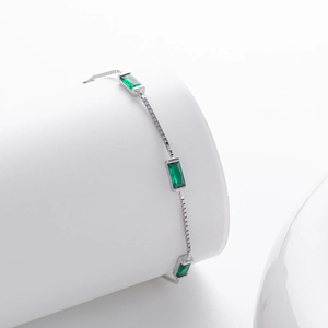 Close-up of elegant 925 silver bracelet with three rectangular green emerald-style gemstones