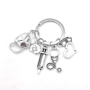 Detailed silver medical keychain with N95 mask, syringe, and nurse cap charms on white backdrop