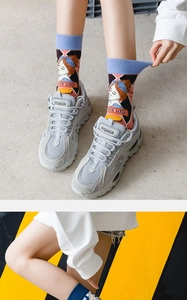 Close-up of Lolita style mid-calf socks with vintage girl illustration and chunky sneakers