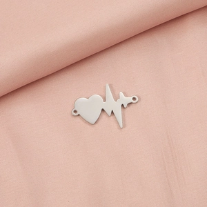 Polished silver heart EKG pendant connector on soft pink fabric background detail