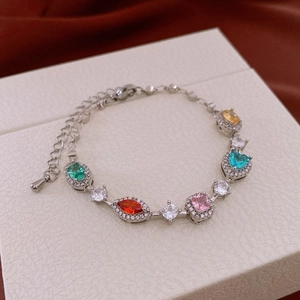 Macro view of adjustable silver bracelet with colorful gradient zircons on a white gift box