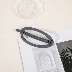 Detailed view of large matte grey oval hair claw clip on a stylish lifestyle background