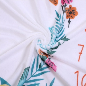 Detailaufnahme der weichen Flanellstruktur und des Blumenmusters auf der Baby-Meilensteindecke