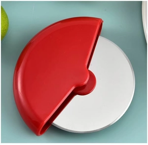 Detail of red pizza wheel cutter with sharp stainless steel blade on light blue background