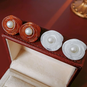 Macro detail of French retro camellia earrings with resin petals and pearl centers