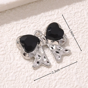 Macro shot showing dimensions 2.3cm by 1.9cm for the black heart bow pendant charm