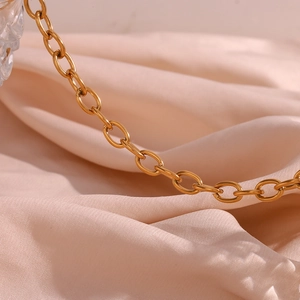 Close-up of elegant 18K gold plated oval link chain on premium pink silk background