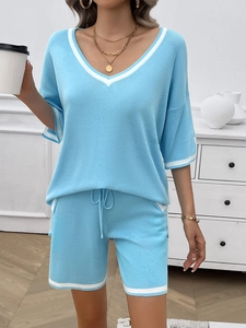 Detail of light blue V-neck knit set with white stripe trim on top and drawstring shorts