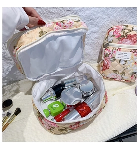 Detailed view of spacious floral quilted makeup bag with zipper closure and interior capacity