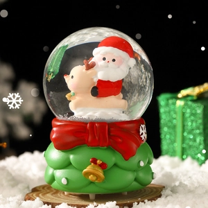Christmas snow globe with Santa and reindeer on a green base with festive Bokeh lighting
