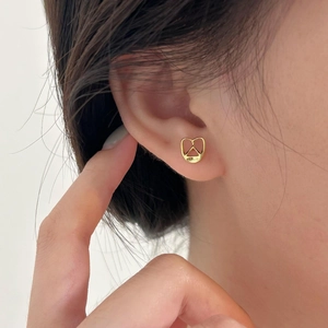 Minimalist 925 sterling silver bread earrings in gold finish worn on earlobe