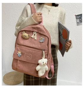 Vista detallada de la mochila escolar de pana rosa con parches de osos y colgante suave