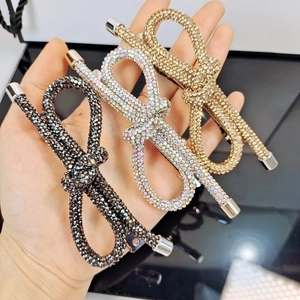 Tre eleganti fermagli per capelli con fiocco di strass in nero, oro e multicolore