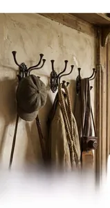 Close-up of vintage cast iron wall hooks with an industrial finish on a rustic wall